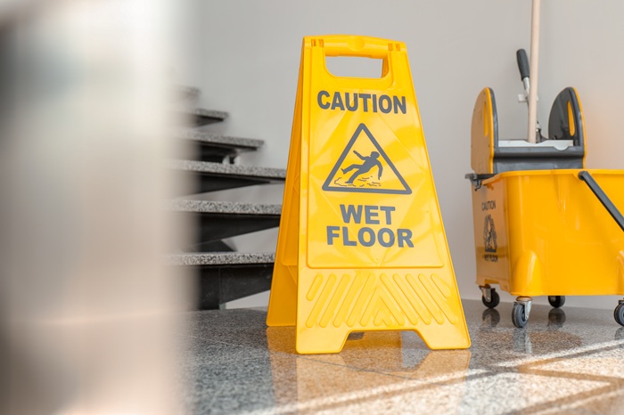 Wet floor warning sign inside a commercial property, highlighting slip and fall hazards and premises liability risks in Abbeville