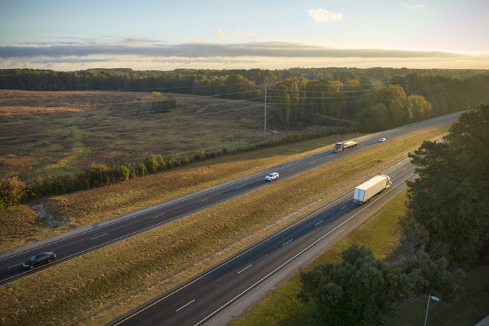 Commercial trucks and passenger vehicles traveling along a rural highway near Abbeville, representing truck accident risks in South Carolina