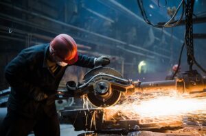 Factory employee operating industrial cutting equipment at an Abbeville job site, highlighting serious workplace accident risks