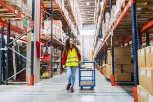 Warehouse worker moving inventory in an Abbeville distribution center while wearing workplace safety gear