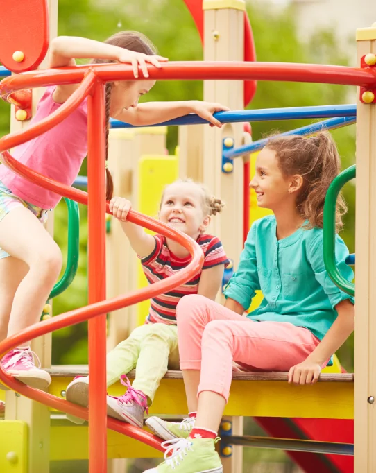 Three young children playing happily on a playground