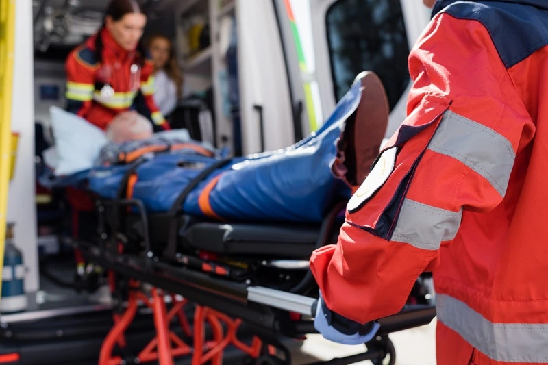 Emergency personnel loading a patient into an ambulance.