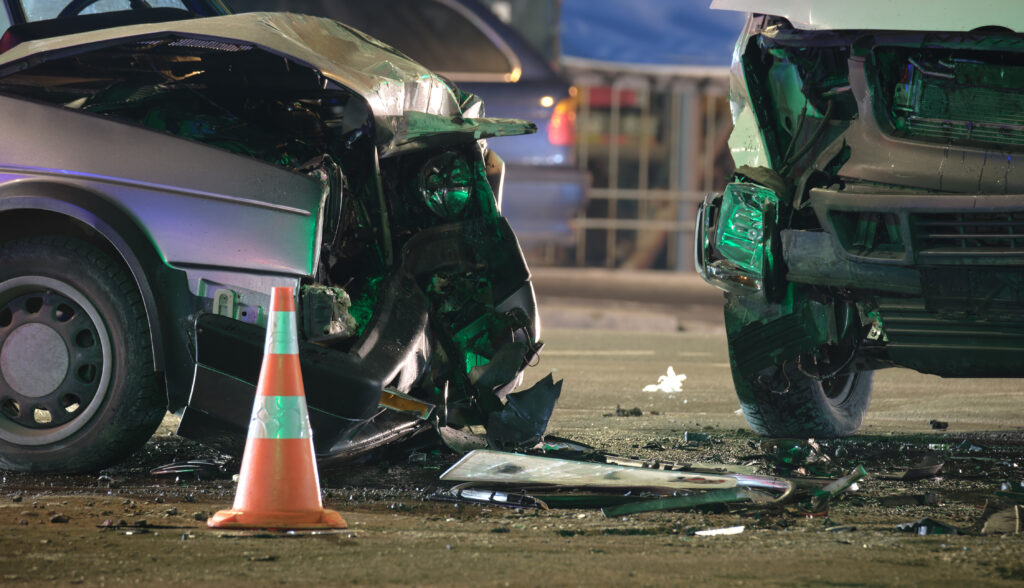 Two cars with significant damage after a nighttime accident.