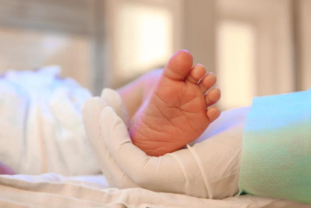 A doctor holds a baby's foot.