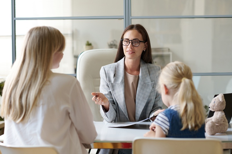 A state worker conducting an interview with a parent and child.