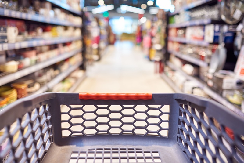 Image of a gray and red shopping cart in grocery store aisle.